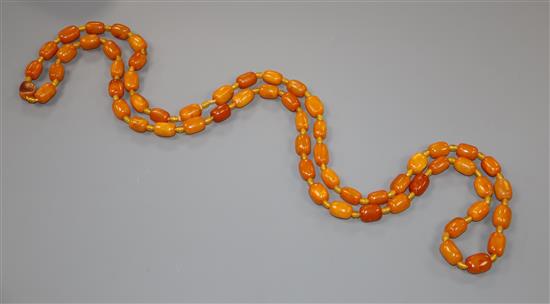 A single strand barrel shaped amber bead necklace, 124cm, gross weight 75 grams.